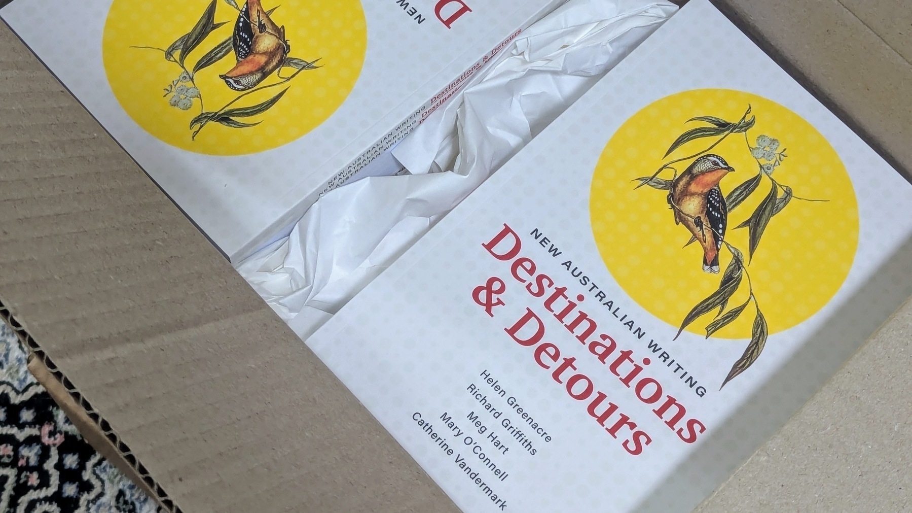 a box of books containing a book titled Destinations and Detours